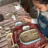 İstanbul Çamlıca’daki Fluu Studio çocuk seramik kursunda el yapımı seramik ev tasarımını boyayan çocuk